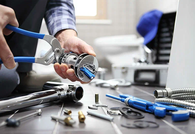 Technician repairing a plumbing fixture with professional tools in Ruskin
