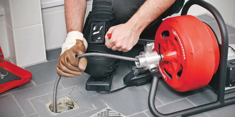 Plumber using a drain-cleaning machine in Ruskin