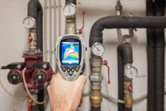 Plumber using a thermal imaging camera to inspect pipes in Ruskin