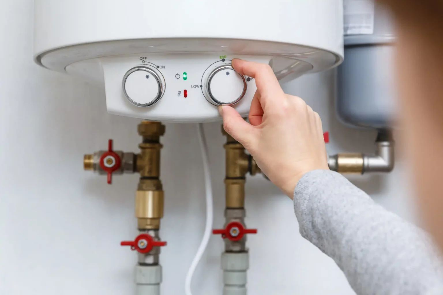 Homeowner adjusting the temperature controls on a water heater in Ruskin